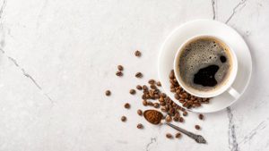 Top view of black coffee in white cup for breakfast on marble background with copy space